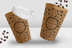 Gobelet en carton couleur craft entiérement personnalisés avec le logo du café "Mokka" et un motif de petites illustrations pictogrammes autour du thème du café (grains de café, sachet de thé etc.)