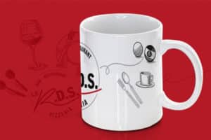 Mug blanc avec le logo "Relais des sports" imprimé dessus et des illustrations de boules de billards, de couverts et d'une tasse de café.