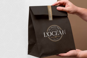 Sachet de vente imprimé avec le logo du restaurant "L'Océan". Étiquette autocollante de fermeturenpersonnalisée.