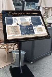 porte menu noir de restaurant lumineux sur pied. ici pour le restaurant L'Abri des flots à Dinard.